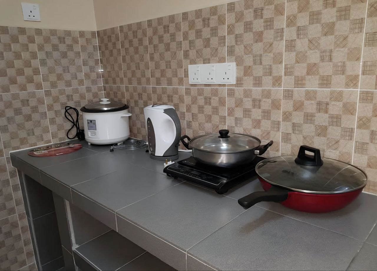 Dapur lengkap dengan periuk nasi, pemanas air, induction cooker dan kuali di Teratak Nipah Homestay